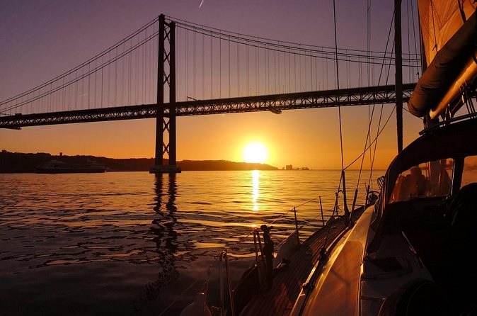 The sun setting under the bridge, seen from beside a sailboat's cockpit