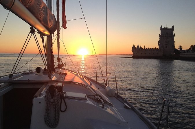 Sunset from a sailboat's deck, with the fortified tower at Belém on the right